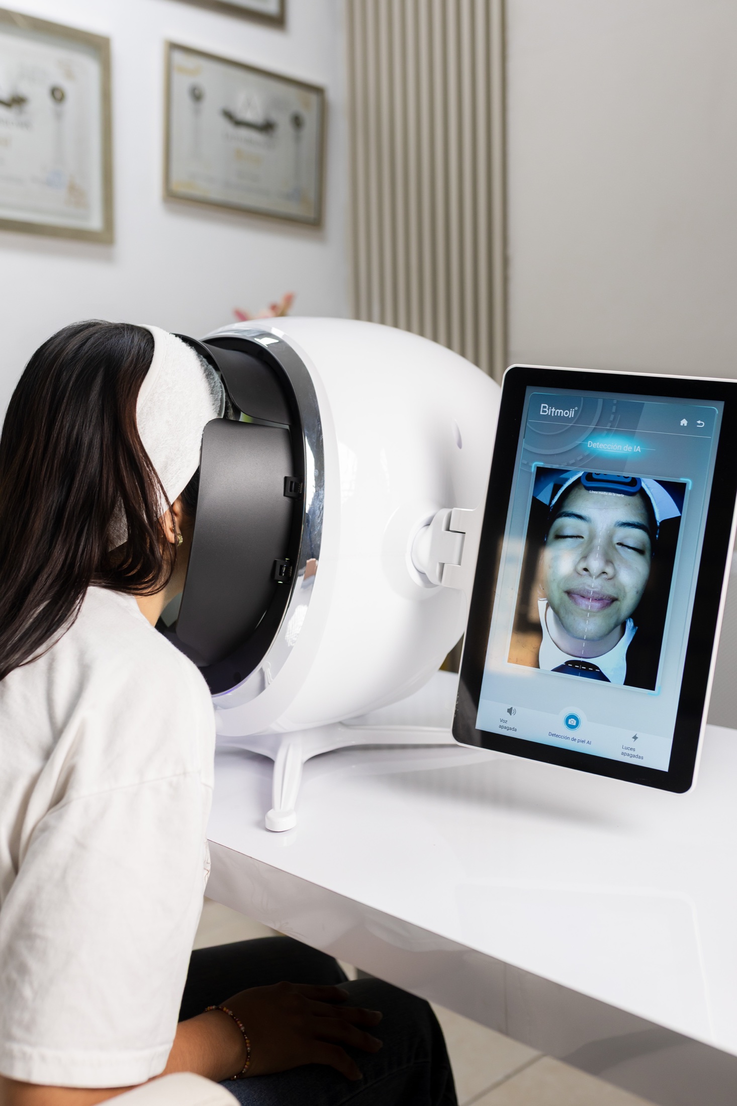 Equipo de diagnóstico facial en el estudio de Carla Caro con certificados profesionales al fondo